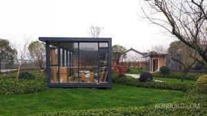 The modern prefabricated resort buildings sit calmly in a natural garden setting.